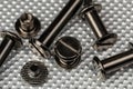 A Macro image of various sized Chicago Screws or Barrel Bolts of varying lengths on a stainless steel industrial background Royalty Free Stock Photo