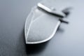 Macro Of A Knife Point Of An Opened Black Folding Knife Which Is Lying On Dark Ground