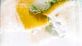 Macro photo of air bubbles on mint leaves and lemon slices in cold water Royalty Free Stock Photo