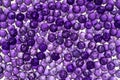 Close up of translucent purple crystals. Purple beads glittering and shining in the light Royalty Free Stock Photo