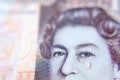 Macro photo of British pound banknote with a water tear drop as a tear on the Queen`s face. Conceptual photo