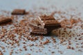 Macro photo of Broken pieces Chocolate bar. Dark chocolate stack with brown powder on a stone background with copy space Royalty Free Stock Photo