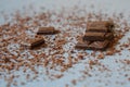 Macro photo of Broken pieces Chocolate bar. Dark chocolate stack with brown powder on a stone background with copy space Royalty Free Stock Photo