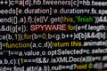 Macro photo of computer screen with program source code and highlighted SPYWARE inscription in the middle. Script on the Royalty Free Stock Photo