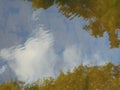 Macro photo with a decorative background of light reflection of green leaves of trees and blue sky with white clouds in the river Royalty Free Stock Photo