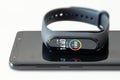 Macro photo of digital fitness tracker smart band with touch screen. on smartphone