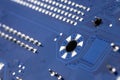 Macro photo of electrical paths on blue circuit board, visible soldering of the semiconductor tip and a screw attachment hole. Royalty Free Stock Photo