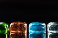 Macro photo of glass cubes of different colors on a black background with reflections Royalty Free Stock Photo