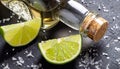 macro photo glasses and bottle of tequila with sliced lime and sprinkled sea salt on black