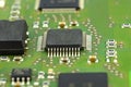Macro photo of integrated circuit on a green circuit board, visible resistors and chip. Royalty Free Stock Photo