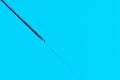 Macro photo of a medical needle from a syringe on a blue background. The concept of vaccination in health care Royalty Free Stock Photo