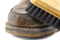 Macro photo of an old brown leather booties polished with paste, shoe brush lies on the shoe, isolated on a white background. Royalty Free Stock Photo