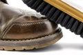 Macro photo of an old brown leather booties polished with paste, shoe brush lies on the shoe, isolated on a white background. Royalty Free Stock Photo