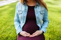 Macro photo, pregnant woman hugs belly