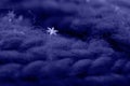 Macro photo of snowflakes on a scarf with a large knit