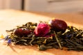 Macro photo of tea with a tea rose. The composition of the heap of tea roses and dried hibiscus flower located on a wooden Board.