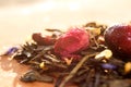 Macro photo of tea with a tea rose. The composition of the heap of tea roses and dried hibiscus flower located on a wooden Board.