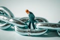 Macro photo of thoughtful businessman figurine standing in a ring of chain. Stressed unemployed miniature man close-up Royalty Free Stock Photo