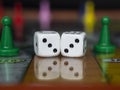 Macro photograhpy to an Old white dices with double three pair and color pawns over a board game Royalty Free Stock Photo