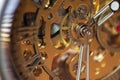 Macro photograph of the internal gears of the machine of a bronze and steel wristwatch. Selective focus