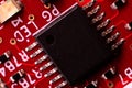 Macro Close-Up of Black Microchip on Red PCB Royalty Free Stock Photo