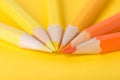 Macro photograph of several pencils of yellow and orange color on a paper background Royalty Free Stock Photo