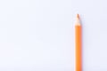 Macro photograph of several pencils of yellow and orange color on a white background