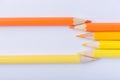 Macro photograph of several pencils of yellow and orange color on a white background Royalty Free Stock Photo