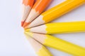 Macro photograph of several pencils of yellow and orange color on a white background Royalty Free Stock Photo