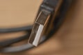Macro close-up of USB Type-C connector with metal housing and blurred cable on wooden surface Royalty Free Stock Photo