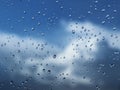 Macro photography of rain drops on the glass on a blurry background of the skyy. Texture in dark and orange tones.