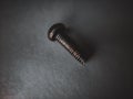 macro photography of a small screw with dark theme.
