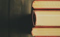 Macro photography of the spine of the book. Spine of books with scarlet covers on a wooden background. Stubs of the book