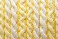 Macro photography of the texture of a knitted pattern in close-up, white and yellow colors, warm clothes Royalty Free Stock Photo