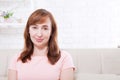 Macro portrait of smiling female face. Attractive and beautiful middle aged woman sitting on sofa and relaxing at home. Menopause Royalty Free Stock Photo