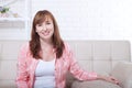 Macro portrait of smiling lady. Attractive and beautiful middle aged woman sitting on sofa and relaxing at home. Menopause.