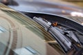 A macro portrait of a windshield wiper of a car standing at its lowest of base position. The blade is resting on the glass of the Royalty Free Stock Photo