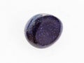 polished blue goldstone gemstone on white marble