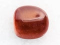 polished red goldstone gemstone on white marble Royalty Free Stock Photo