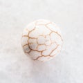 ball from cracked Cacholong gemstone on white