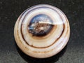 Bead from banded agate gemstone on dark