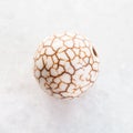 bead from cracked Cacholong gemstone on white Royalty Free Stock Photo