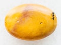 cabochon from yellow Mookaite gemstone on white