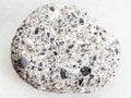 pebble of gray Arkose sandstone on white marble Royalty Free Stock Photo