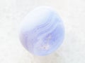 polished blue chalcedony gemstone on white marble Royalty Free Stock Photo