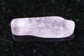 polished kunzite gemstone on dark background