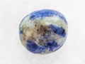 polished Sodalite gem stone on white marble Royalty Free Stock Photo