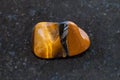 polished tiger eye gemstone on dark background Royalty Free Stock Photo