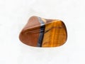 polished tiger eye gemstone on white marble Royalty Free Stock Photo