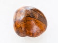 polished tiger-eye stone on white marble Royalty Free Stock Photo